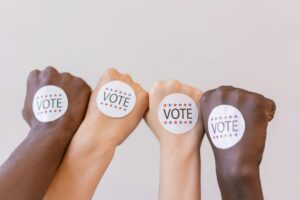 Close Up Photo of Vote stickers on People's Fist